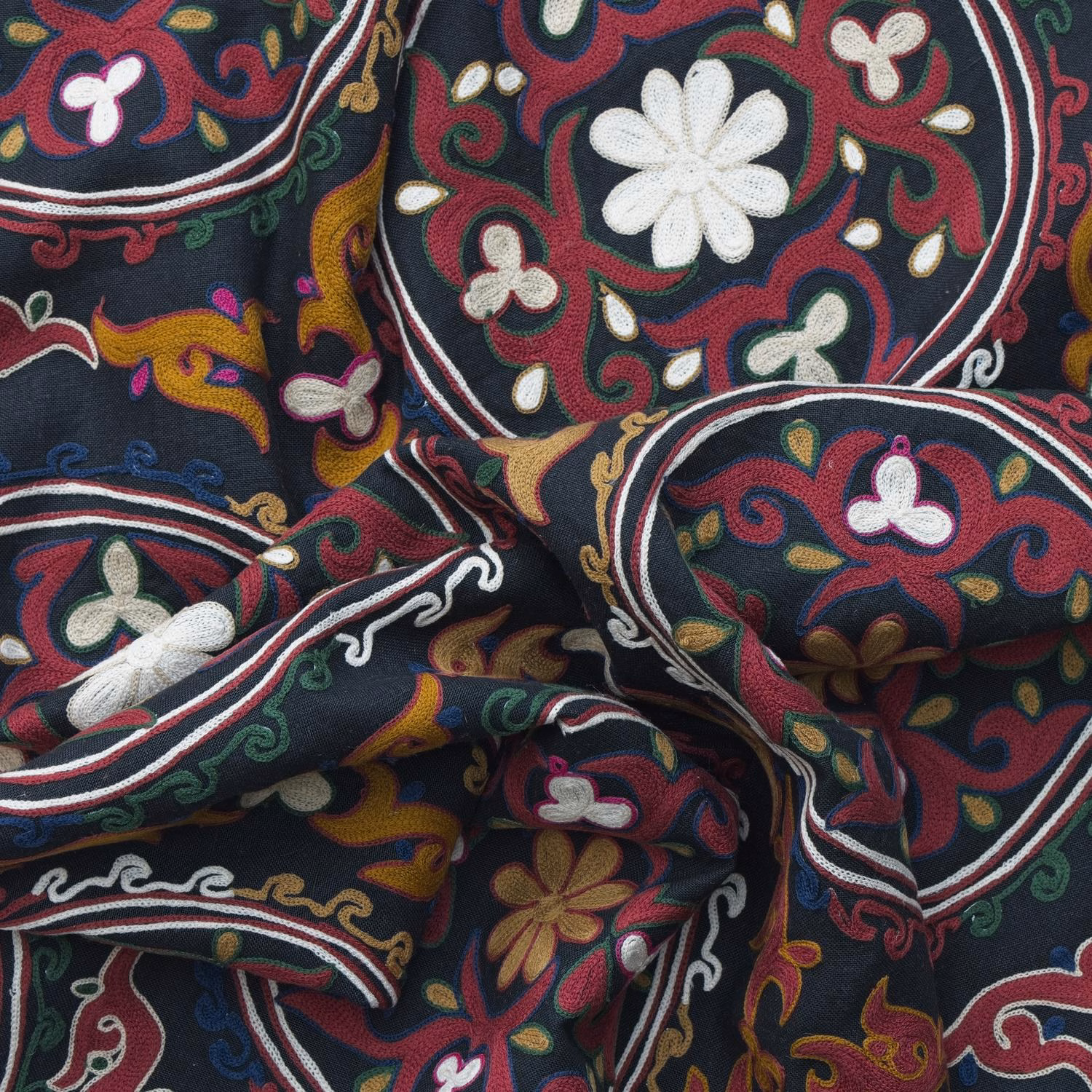 Ember-red paisley and cream flowers on a folded navy patterned textile