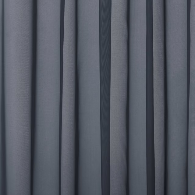 Close-up of cool blue-grey plain curtain fabric with soft folded drape