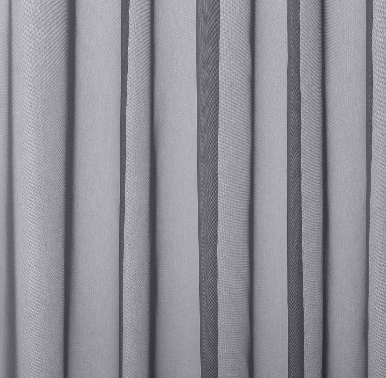 Cool pale grey drapery fabric hanging in soft vertical folds