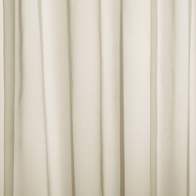 Pale oyster cream plain fabric hanging in soft vertical folds