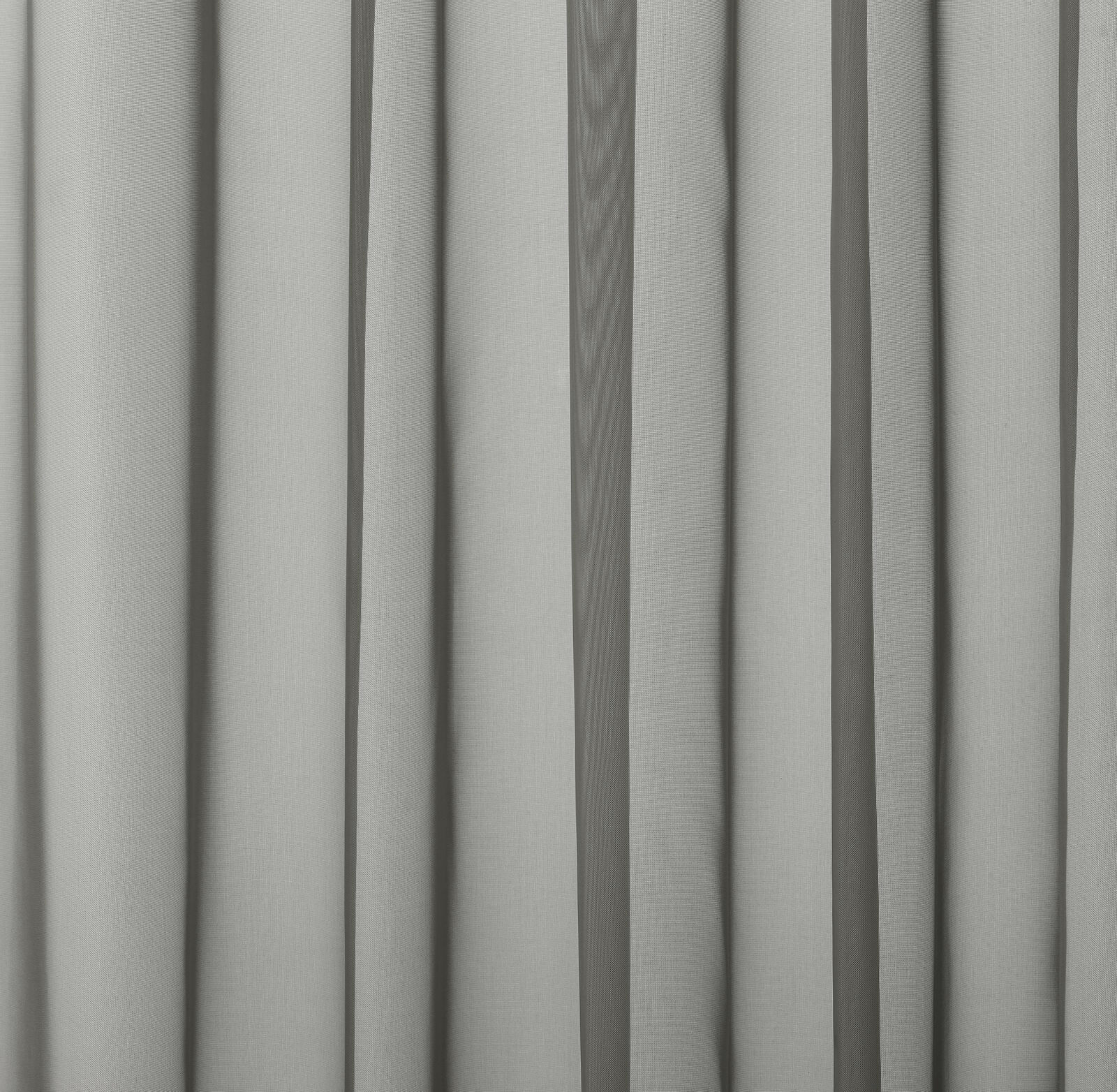 Soft pebble grey plain fabric hanging in narrow vertical folds