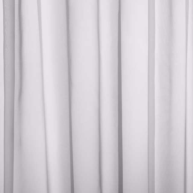Soft icy white plain curtain fabric shown in gentle vertical folds