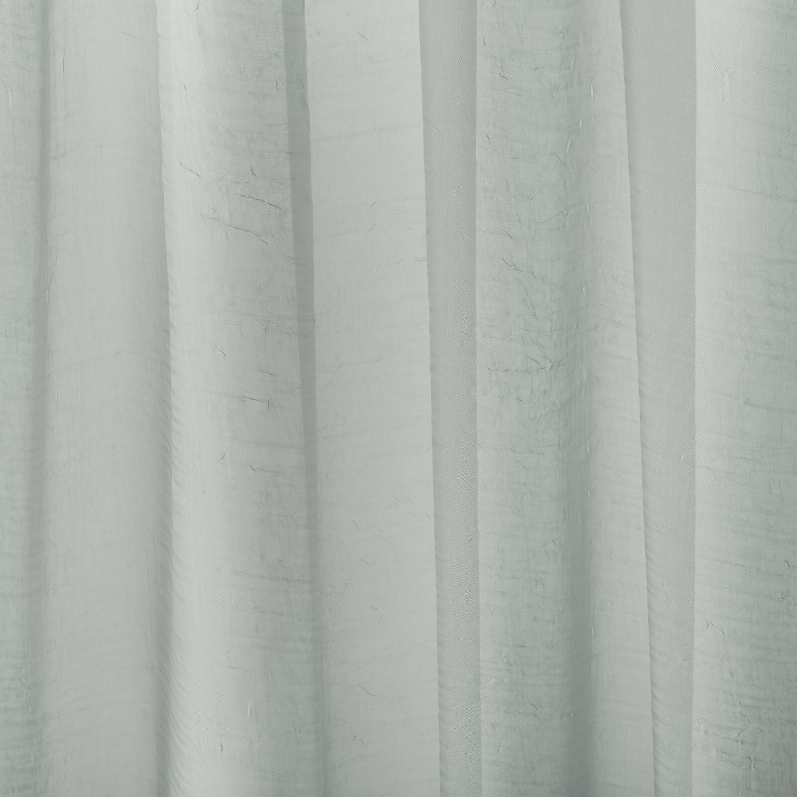 Pale sage-grey plain curtain fabric with soft vertical folds and a subtle slub texture