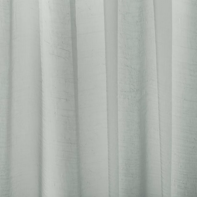 Pale sage-grey plain curtain fabric with soft vertical folds and a subtle slub texture