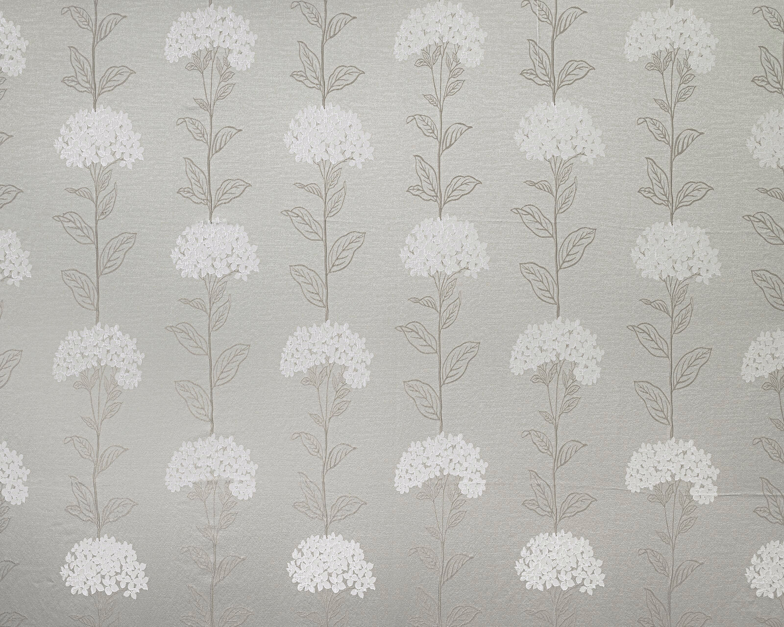 Soft beige floral drapery fabric with pale clustered blooms and fine leaf stems