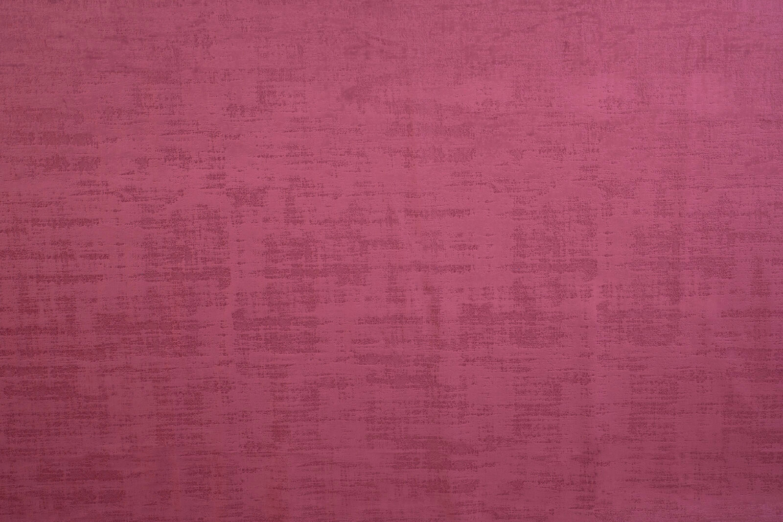 Berry pink textured plain fabric swatch with a brushed, weathered finish