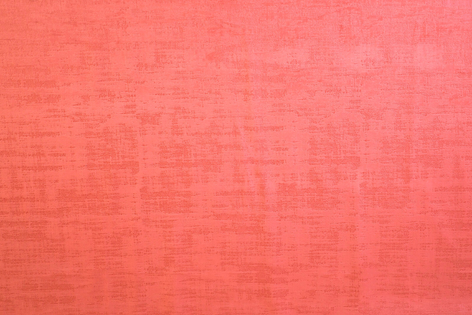 Bright coral pink textured plain fabric with a softly mottled weave