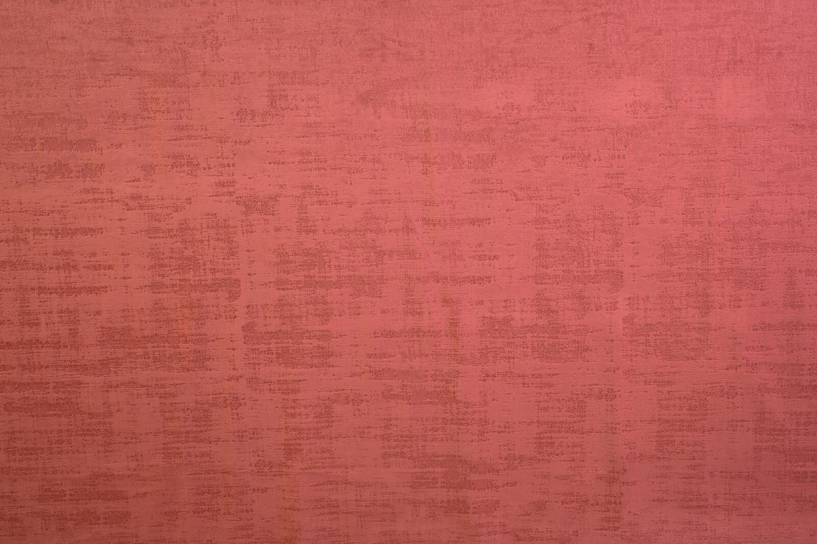 Close-up of dusty crimson textured plain fabric with mottled weave