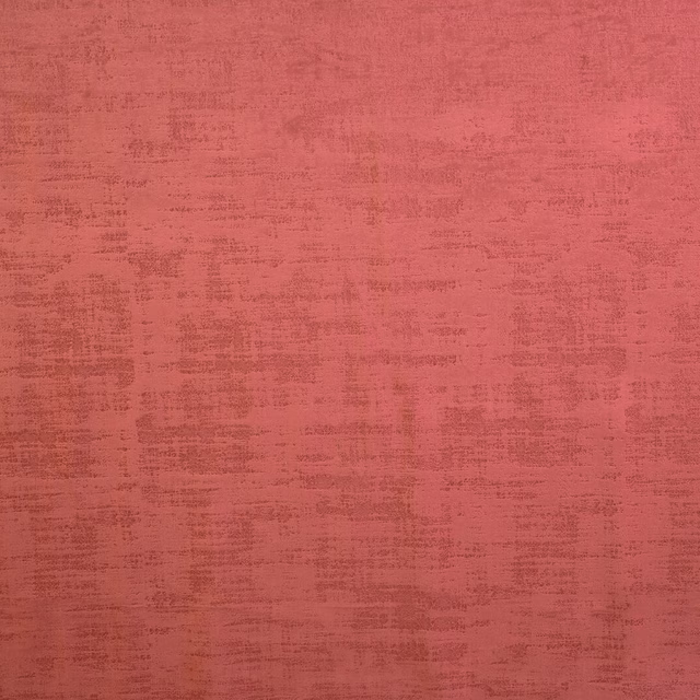 Close-up of dusty crimson textured plain fabric with mottled weave