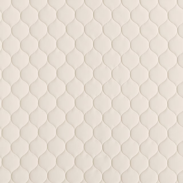 Warm ivory cream fabric with small raised teardrop pattern and soft matte texture
