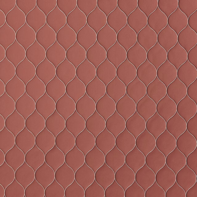 Muted coral terracotta fabric with a small looped lattice pattern