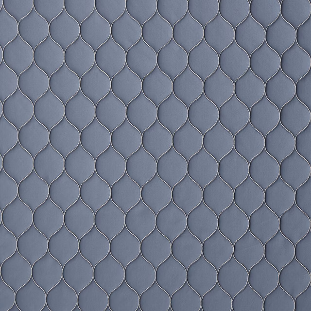 Close-up of muted slate-blue woven fabric with small repeating linked motif