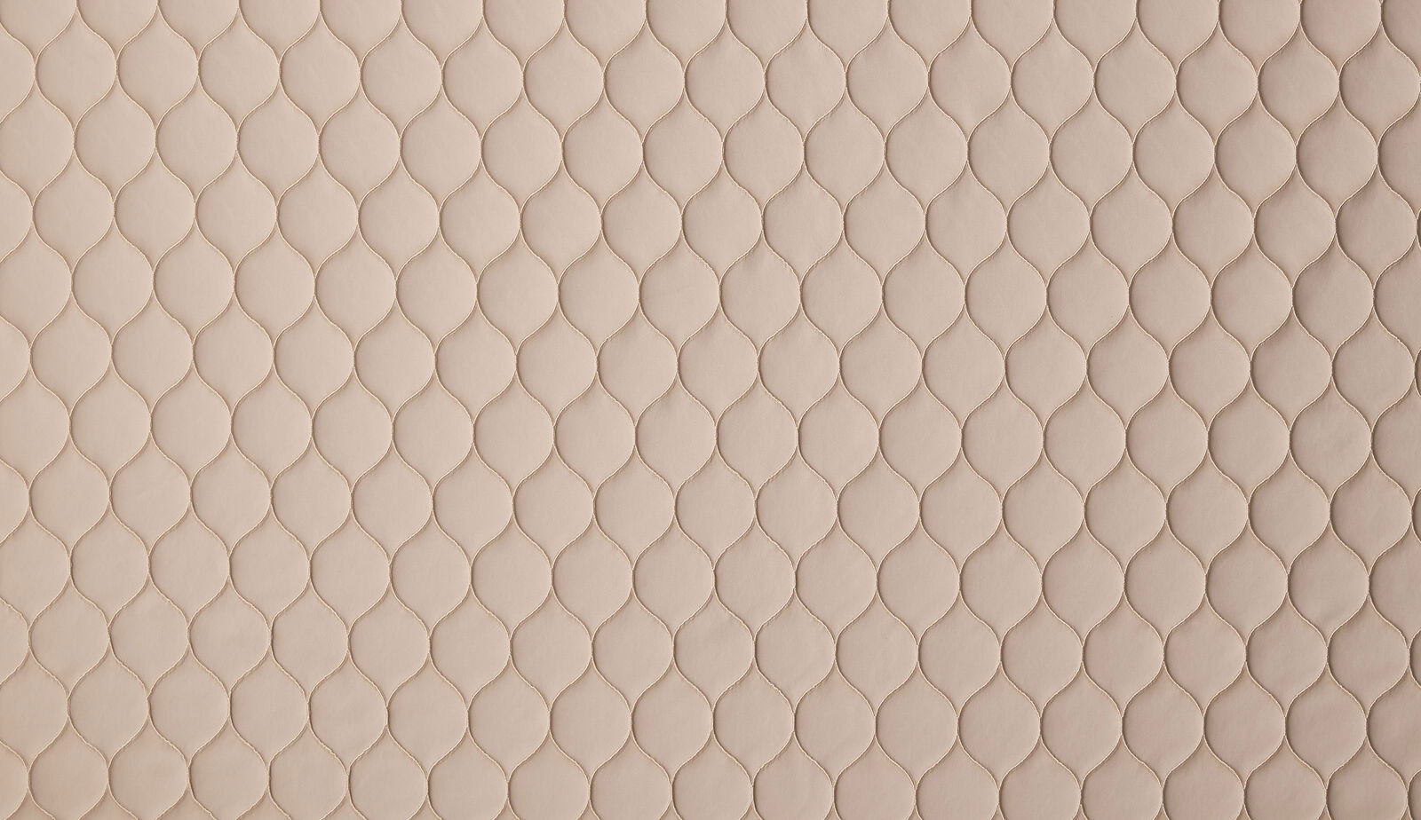 Close-up of shell-beige woven fabric with small embossed leaf-like texture