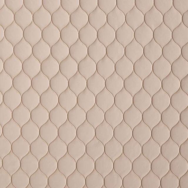Close-up of shell-beige woven fabric with small embossed leaf-like texture