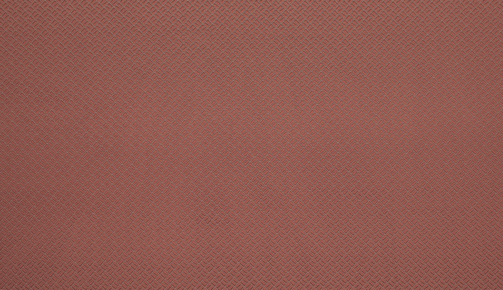 Soft coral terracotta fabric with a small geometric woven texture
