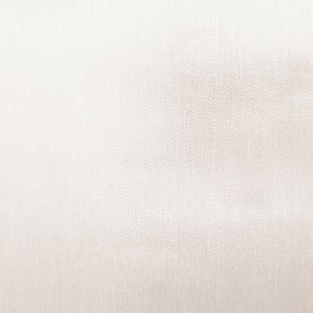 Close-up of a soft ivory plain woven fabric with a smooth matte finish