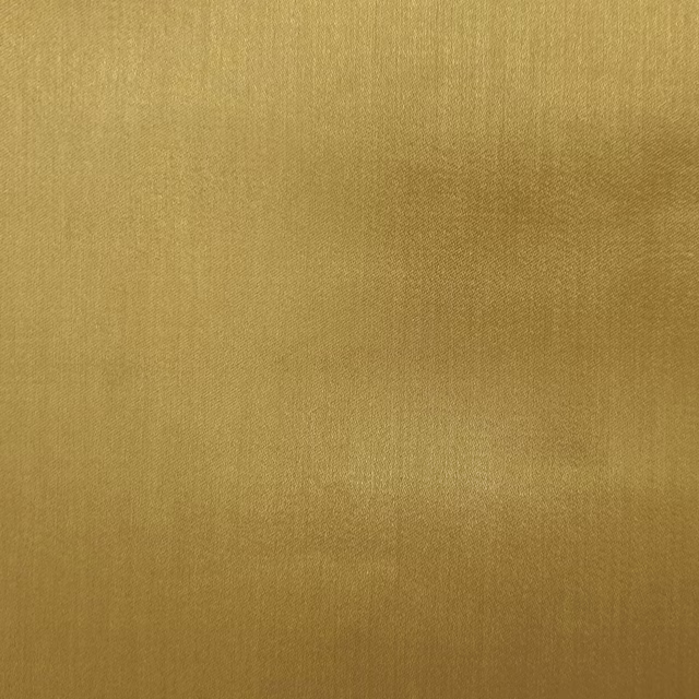 Close-up of plain mustard-gold fabric with a soft satin sheen