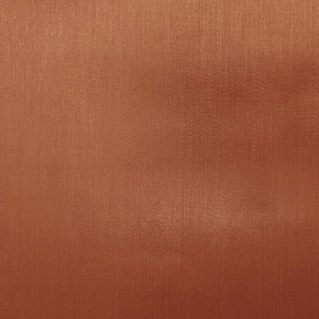 Warm terracotta plain fabric with a smooth, softly mottled woven surface