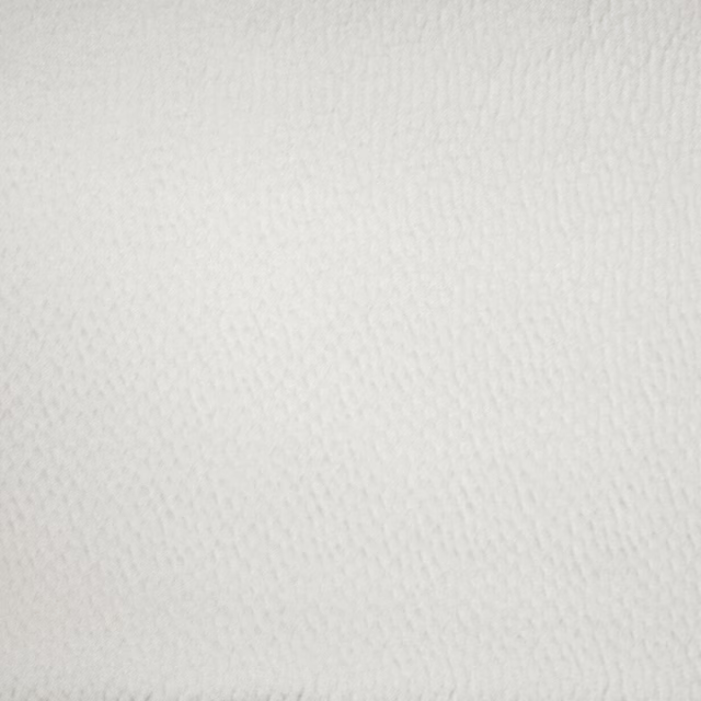 Close-up of soft silver-white textured woven fabric with a subtle diagonal grain