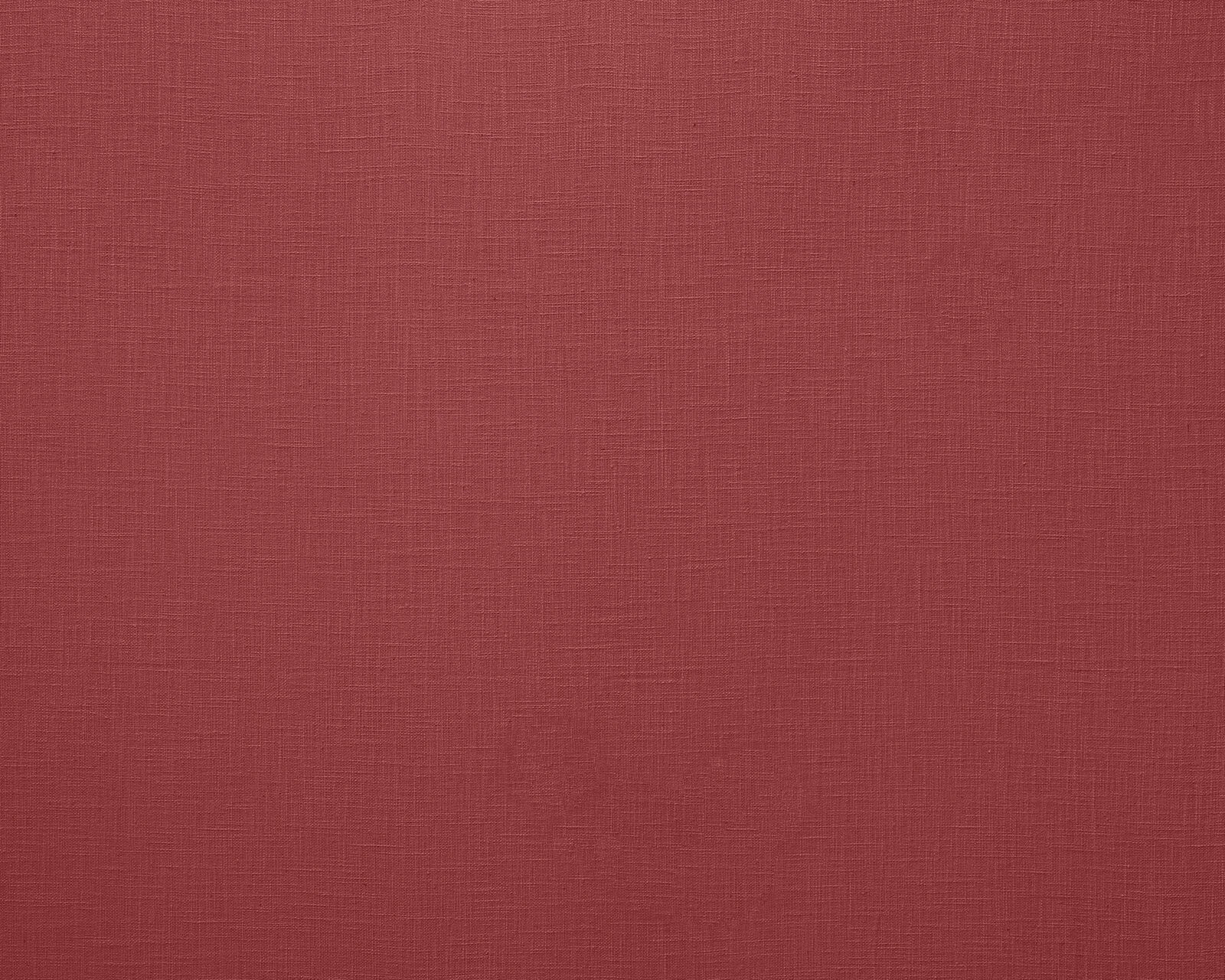 Close-up of deep cranberry red plain woven fabric with fine linen texture