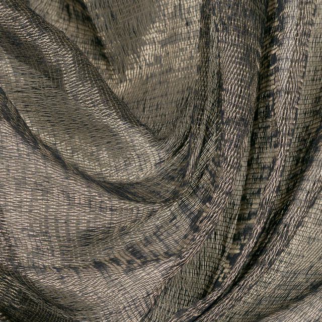 Soft gold and charcoal open weave falling in deep, fluid folds