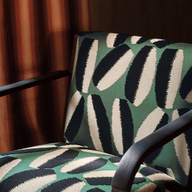 Malachite green upholstery with black and cream elongated organic motifs on chair