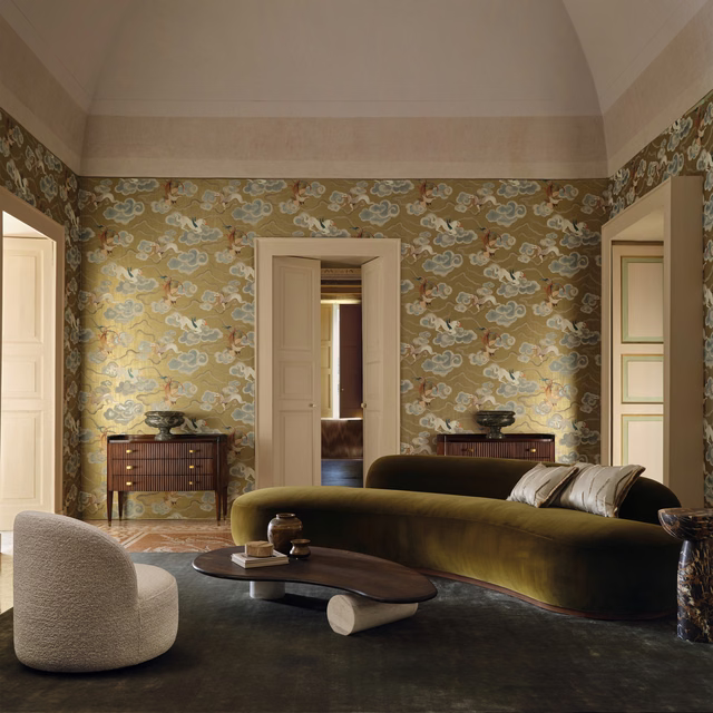 Muted olive-gold wallpaper with pale cloud-like motifs and warm gilded accents.
