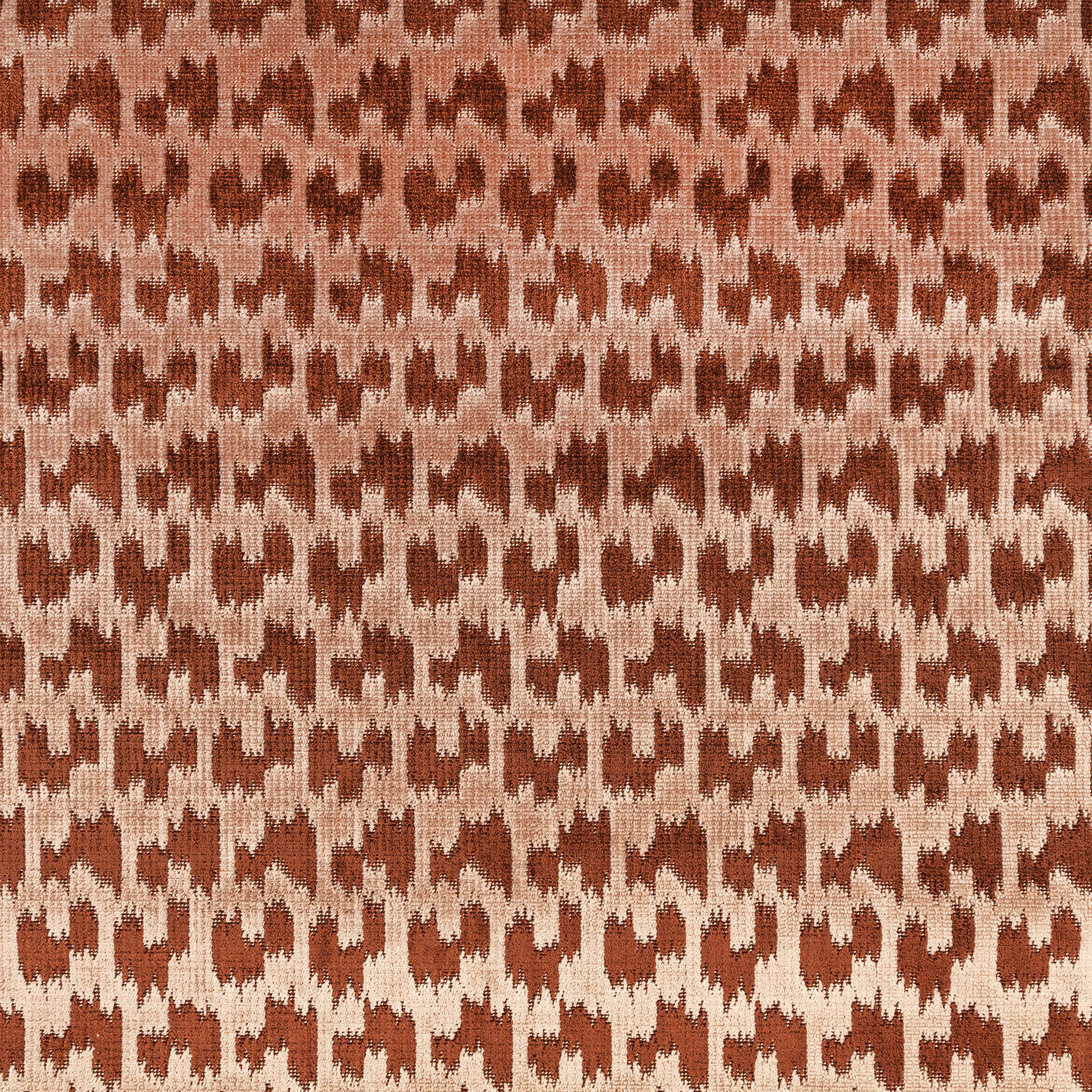 Muted rust and beige ikat-like geometric weave with a tactile surface