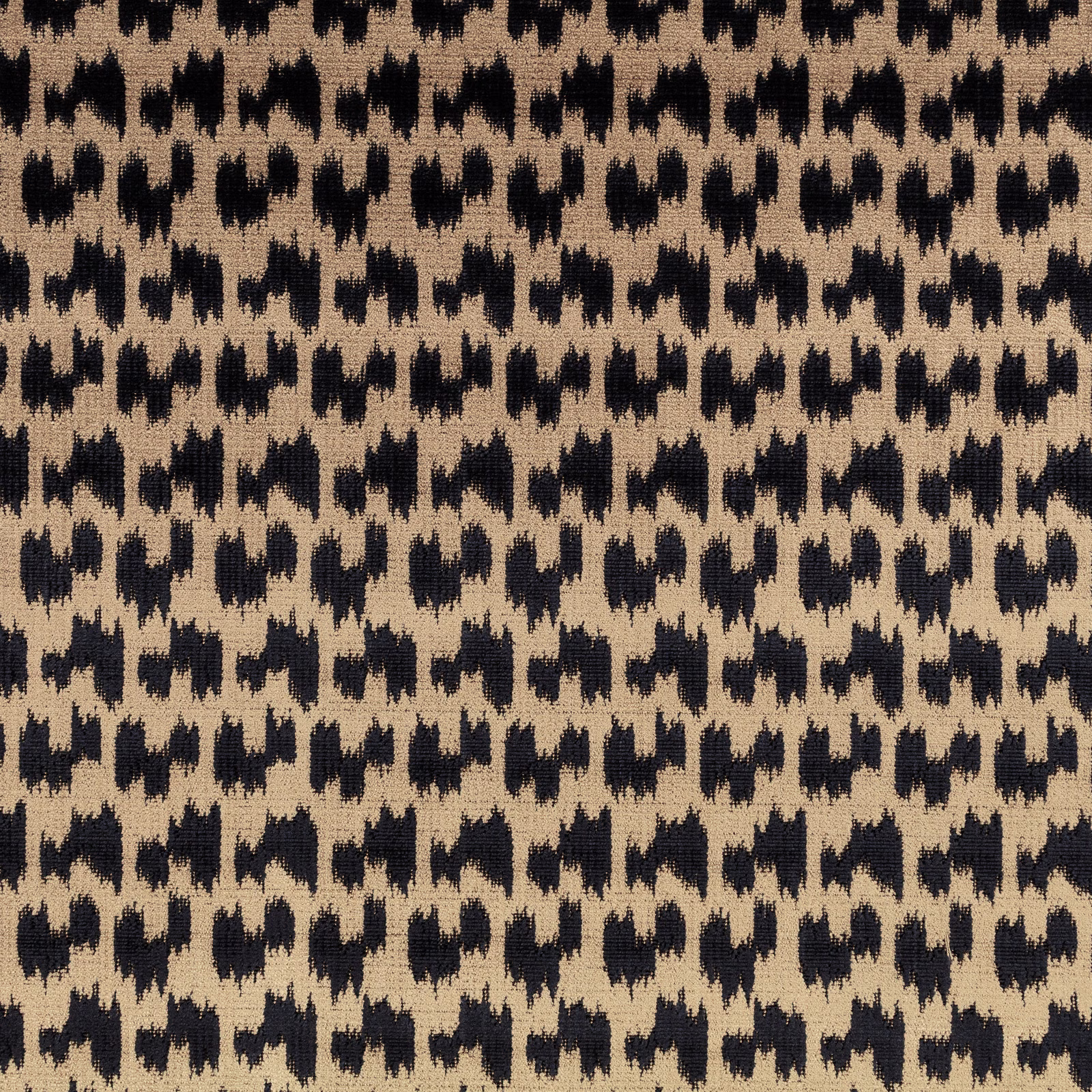Warm spice woven fabric with repeated irregular black ikat-style motifs and tactile texture