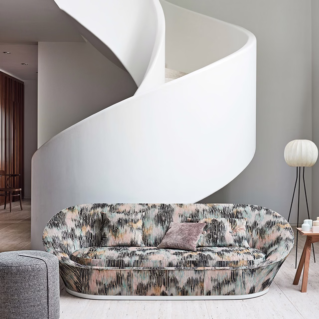 Blush pink jacquard with charcoal and pale blue vertical brush marks on curved sofa