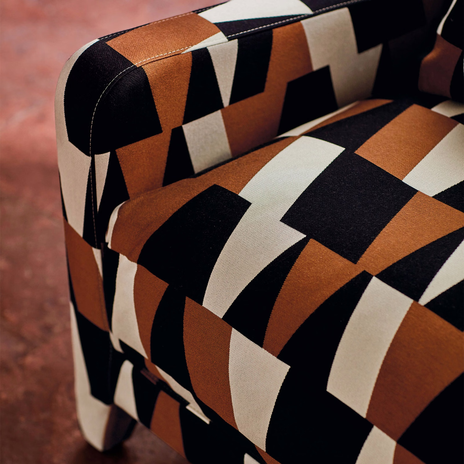 Arku Copper upholstery showing copper, black and ivory geometric blocks on a curved chair