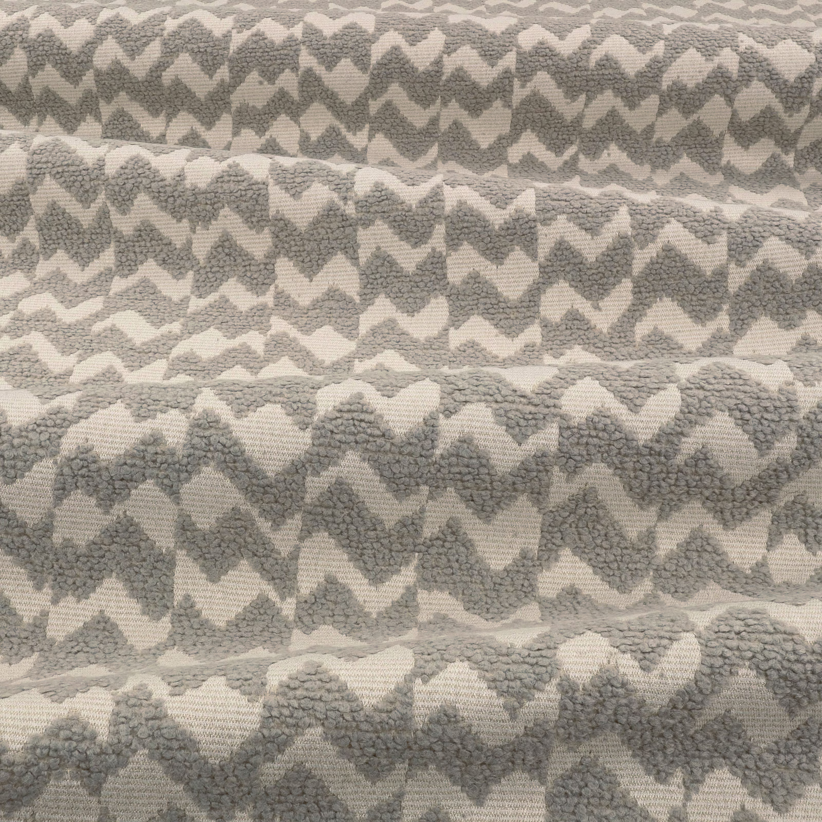 Mottled stone-grey and ivory textile with raised irregular chevron weave