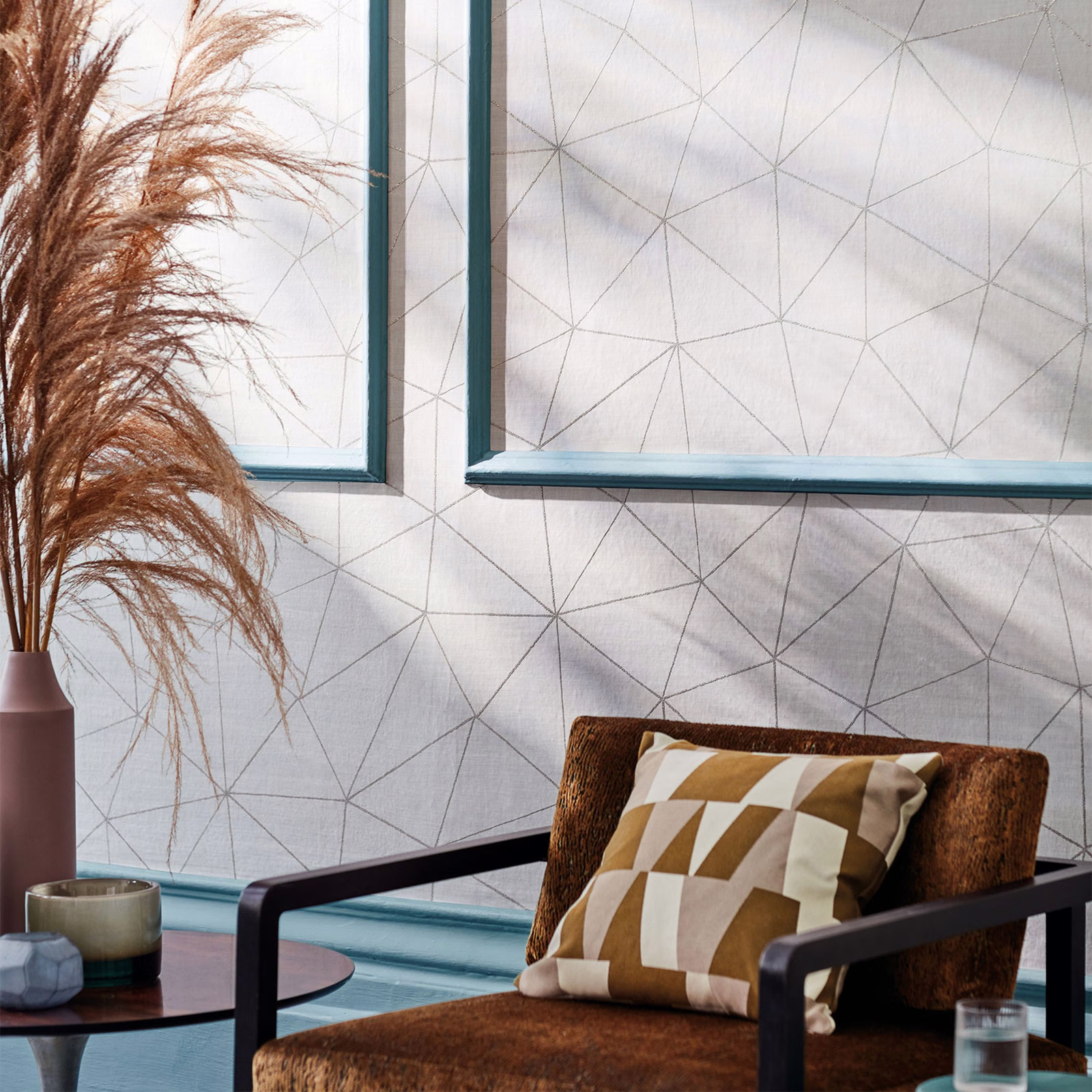 Pale warm-grey geometric wallpaper with fine charcoal polygon lines in a styled room
