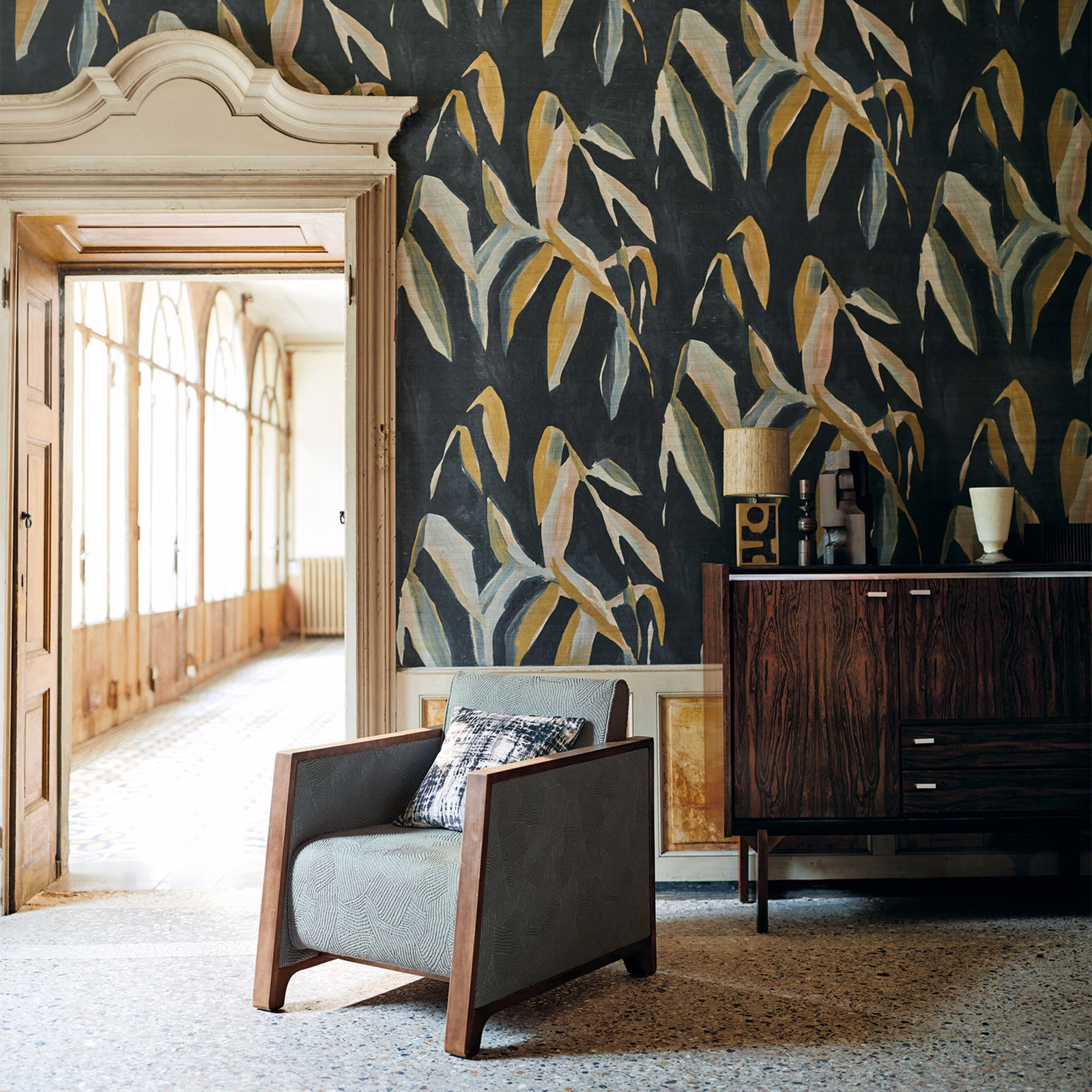 Charcoal wallpaper with sweeping ochre, cream, sage and blue-grey leaf motifs