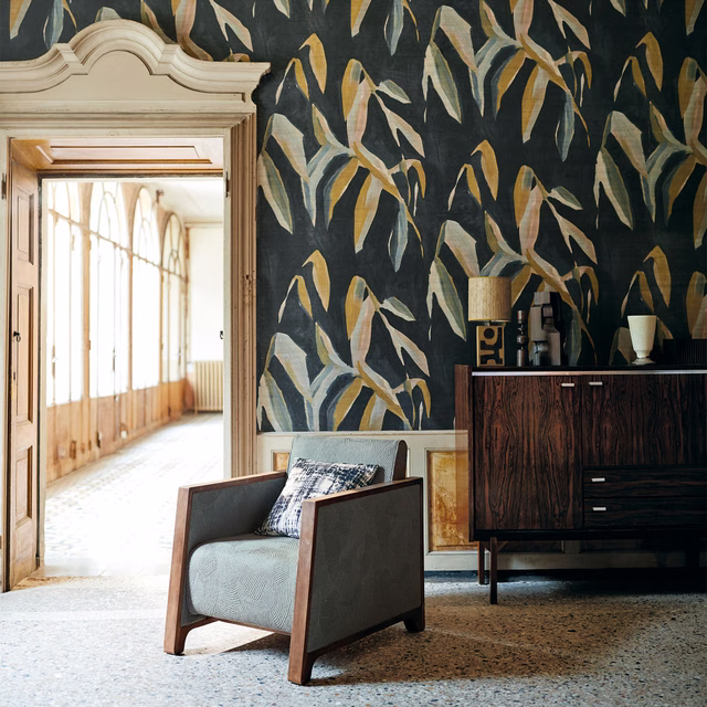 Charcoal wallpaper with sweeping ochre, cream, sage and blue-grey leaf motifs