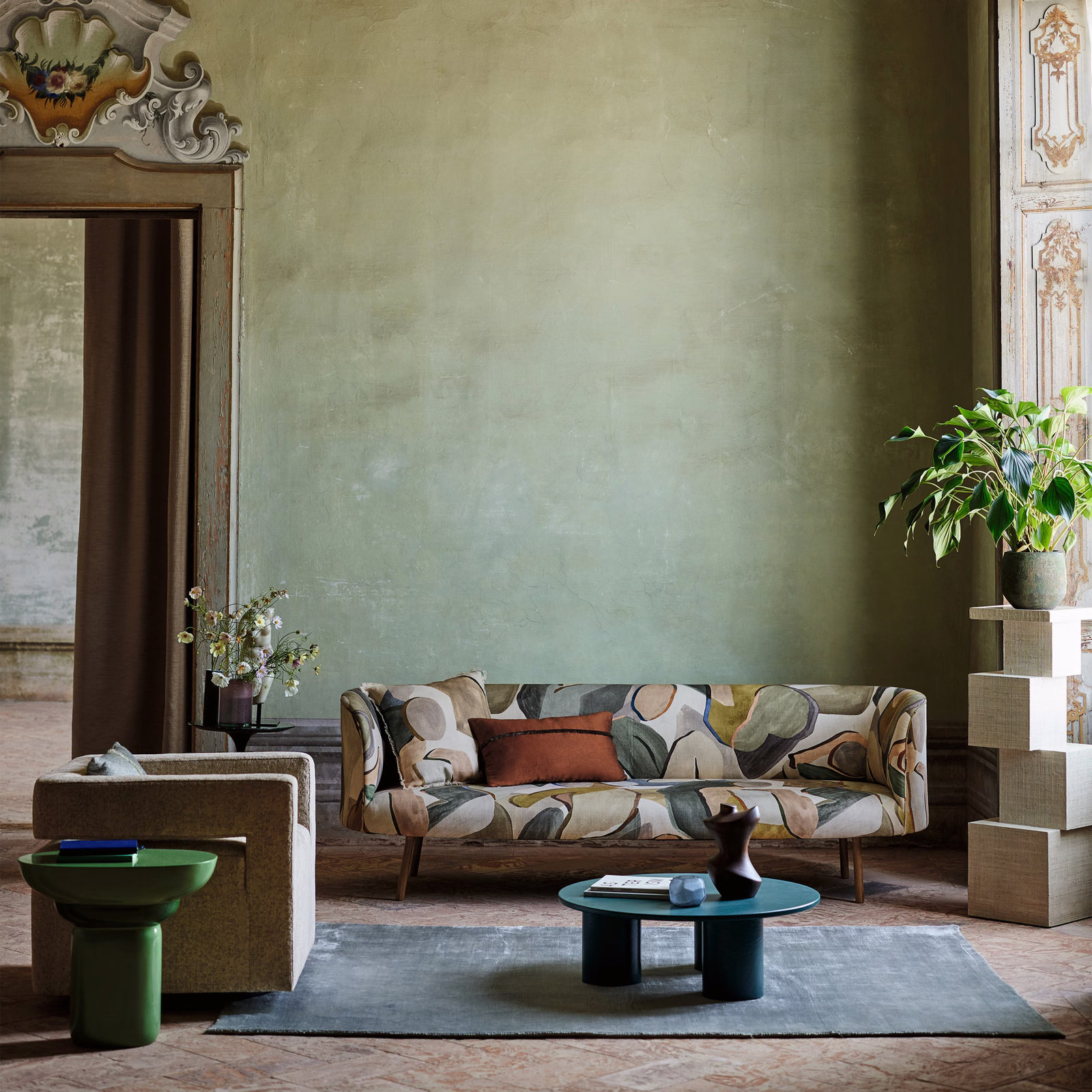 Muted sage and olive upholstery with oversized pebble motifs, rust and cream accents