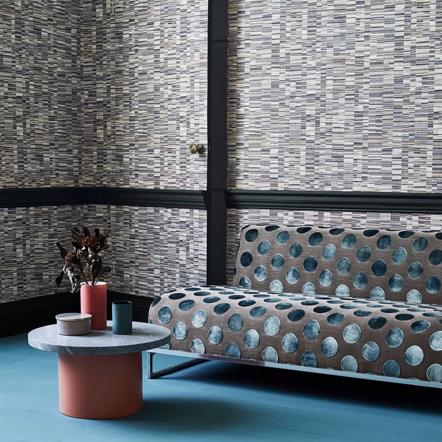 Stone-grey wallcovering with fine charcoal and ivory horizontal striations behind a sofa