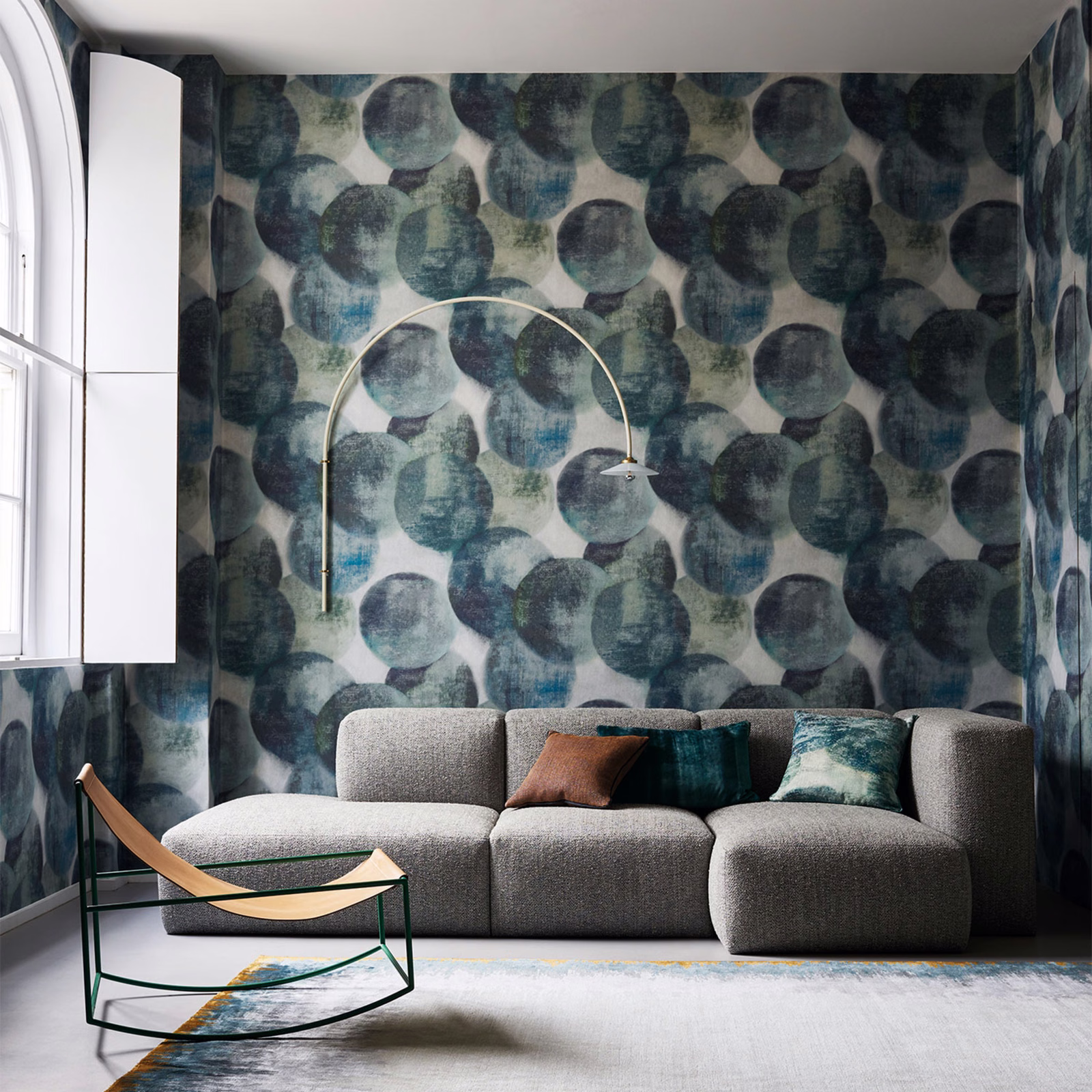 Layered peacock teal, blue-grey and charcoal circles on a pale wallpaper ground