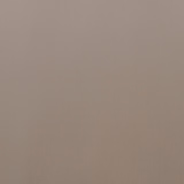 Close-up of plain warm taupe velvet with softly shifting vertical pile texture