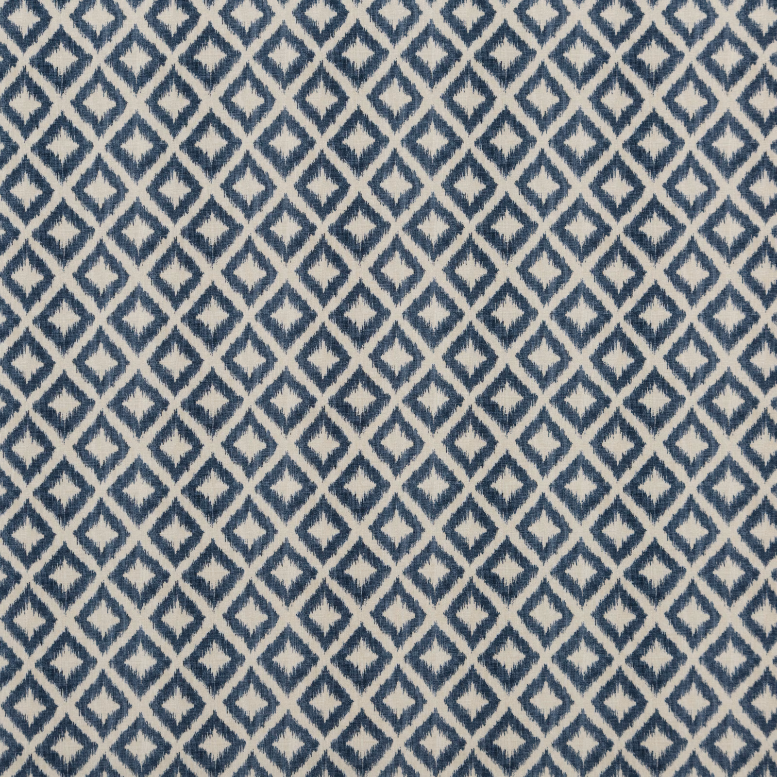 Close-up of muted indigo diamond lattice woven over a warm ivory ground