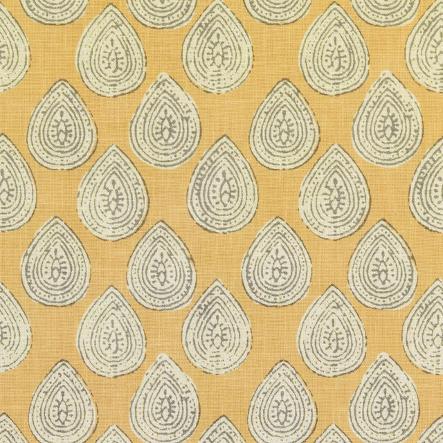 Ochre yellow fabric with repeating pebble-toned teardrop motifs and fine woven texture