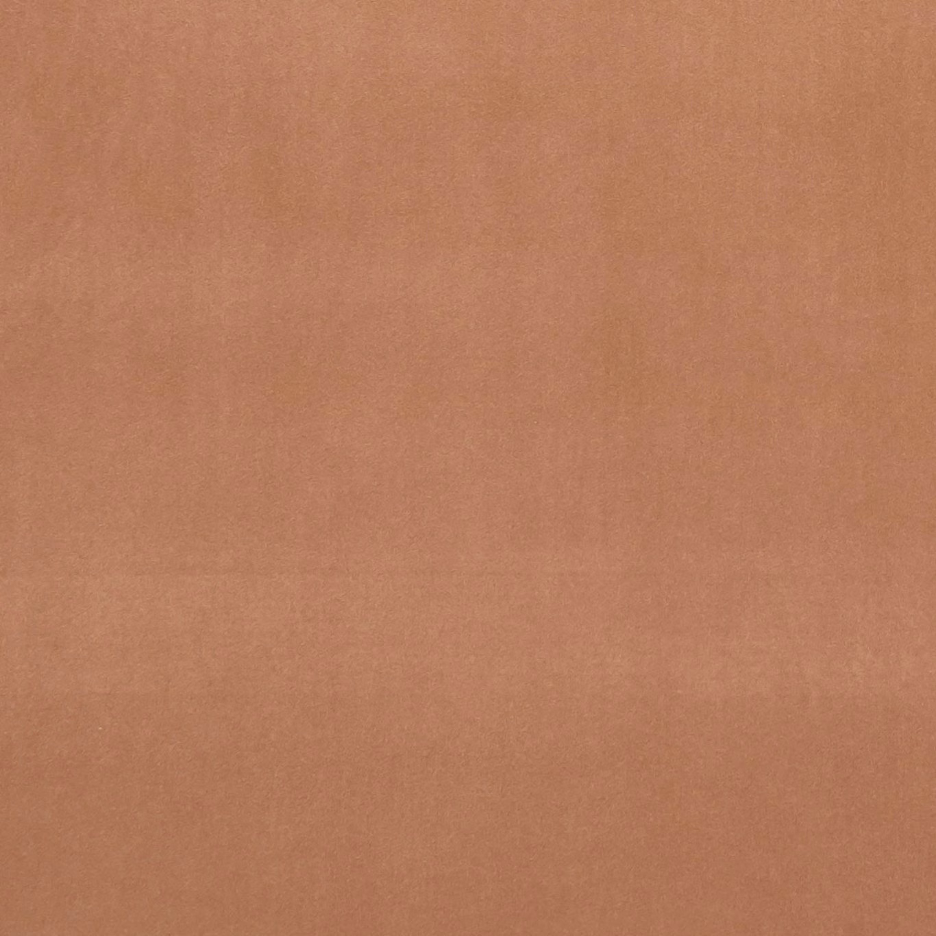 Close-up of plain muted sienna terracotta fabric with a soft, even texture
