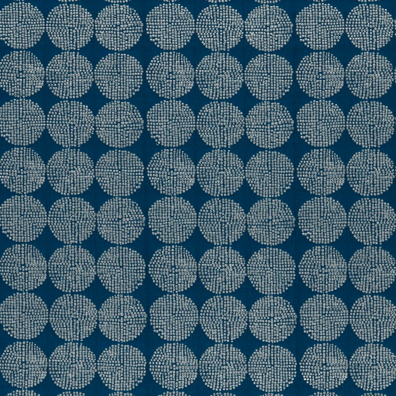 Deep aqua-teal fabric with pale dotted circular medallions in a regular woven repeat