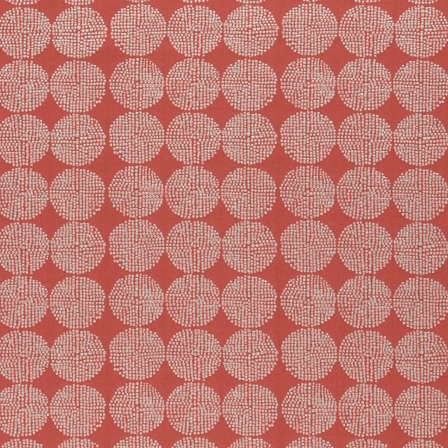 Warm brick-red textile with repeating ivory dotted circular motifs and tactile woven texture