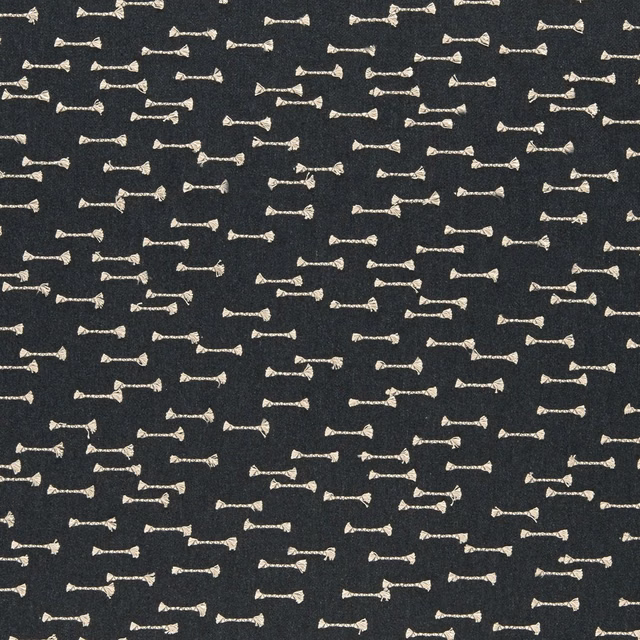 Charcoal woven upholstery with scattered small ivory bow-tie motifs and tactile texture