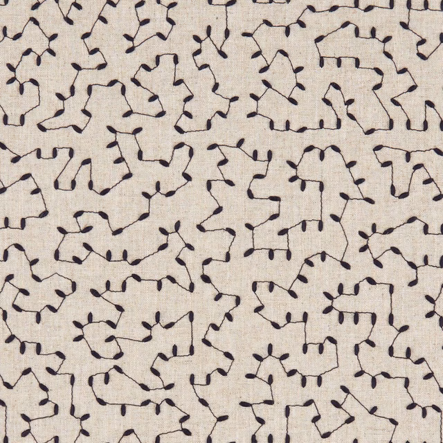 Warm ivory fabric with small looping navy tracery and a subtly textured woven surface