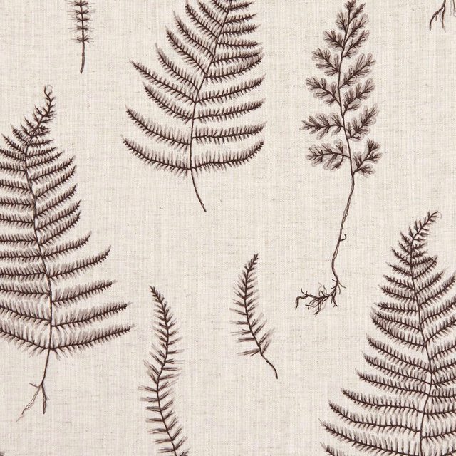 Charcoal fern fronds and seedheads scattered across a textured linen-coloured fabric ground