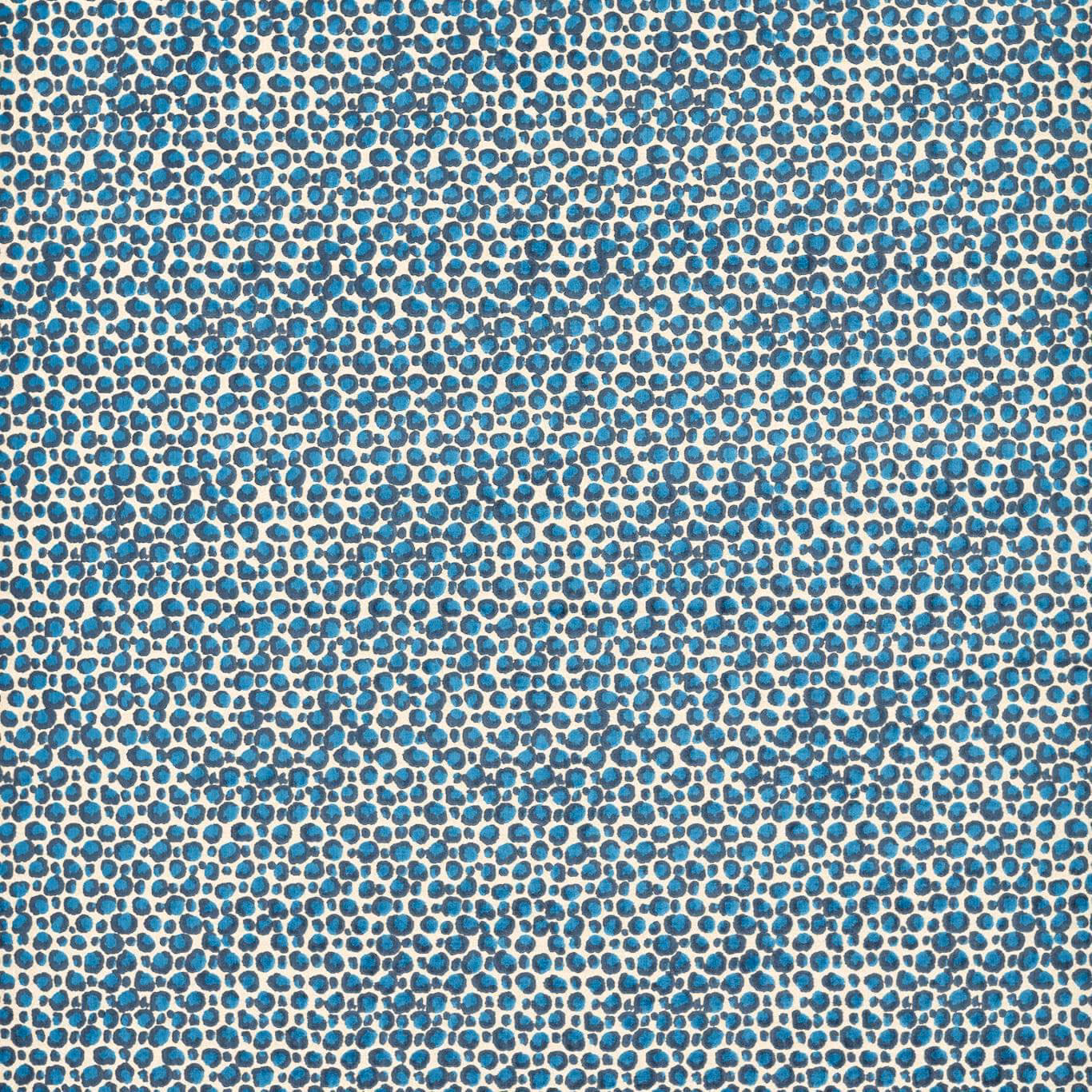 Turquoise and navy pebble motif woven across a warm ivory ground
