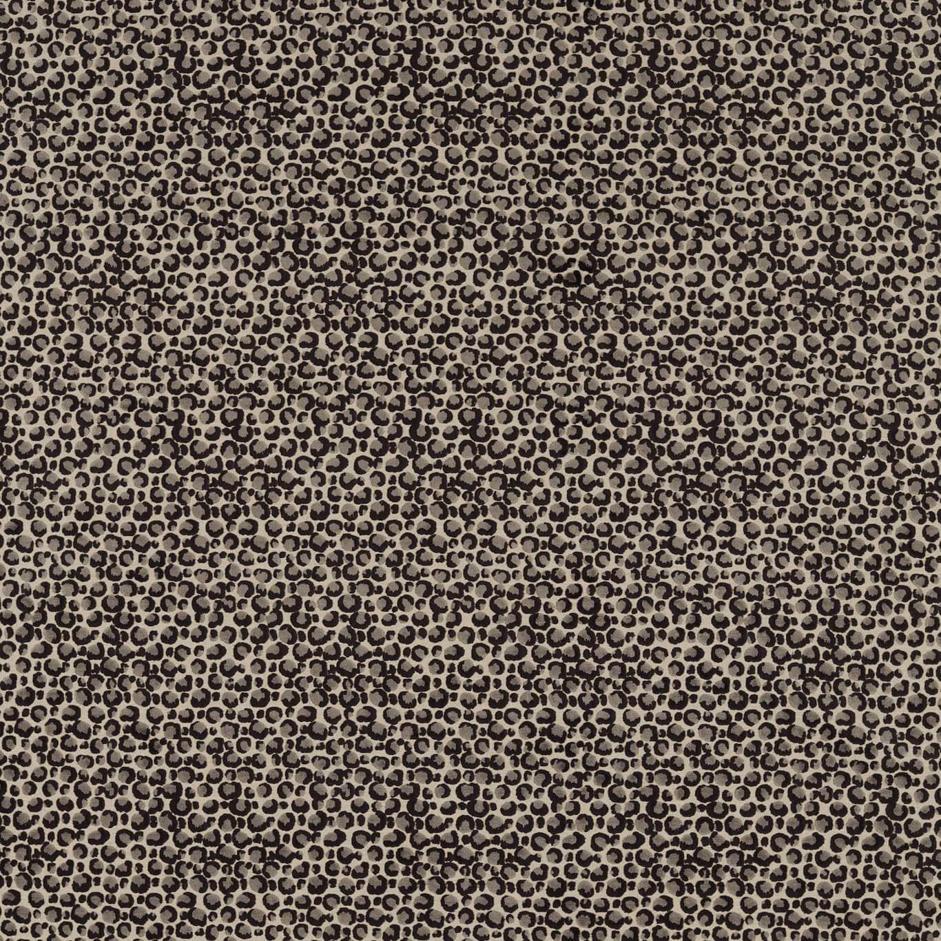 Close-up of dense black ring-like spots woven across a warm taupe ground