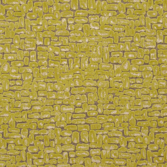 Warm citrus-lime textile with raised pebble-like geometric blocks and silvery highlights